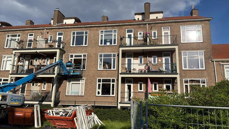 Achtergevel van BGS Rotterdam met hoogwerker tijdens de kozijnvervanging