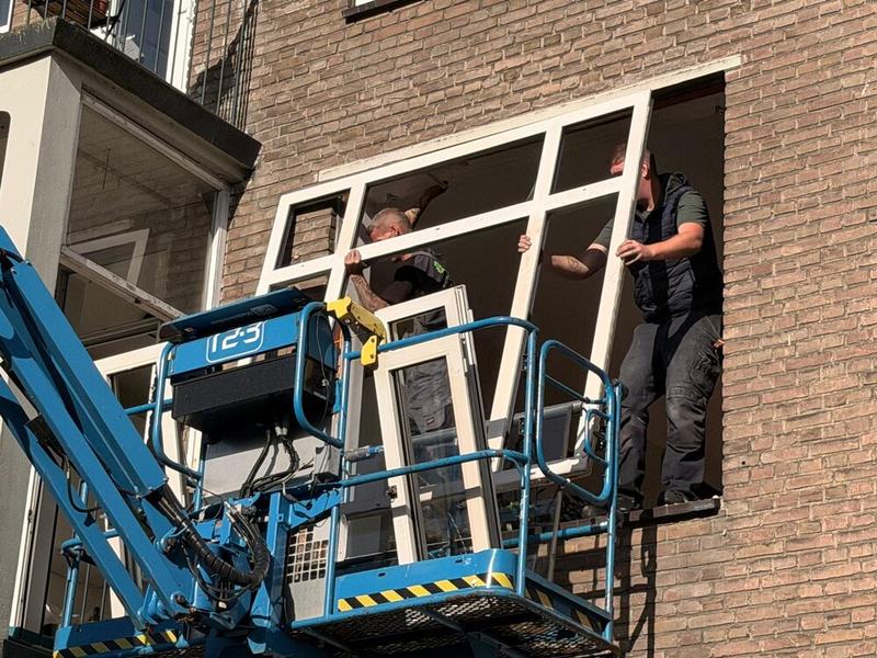 Montageploeg stelt het nieuwe kozijn af vanuit de hoogwerker