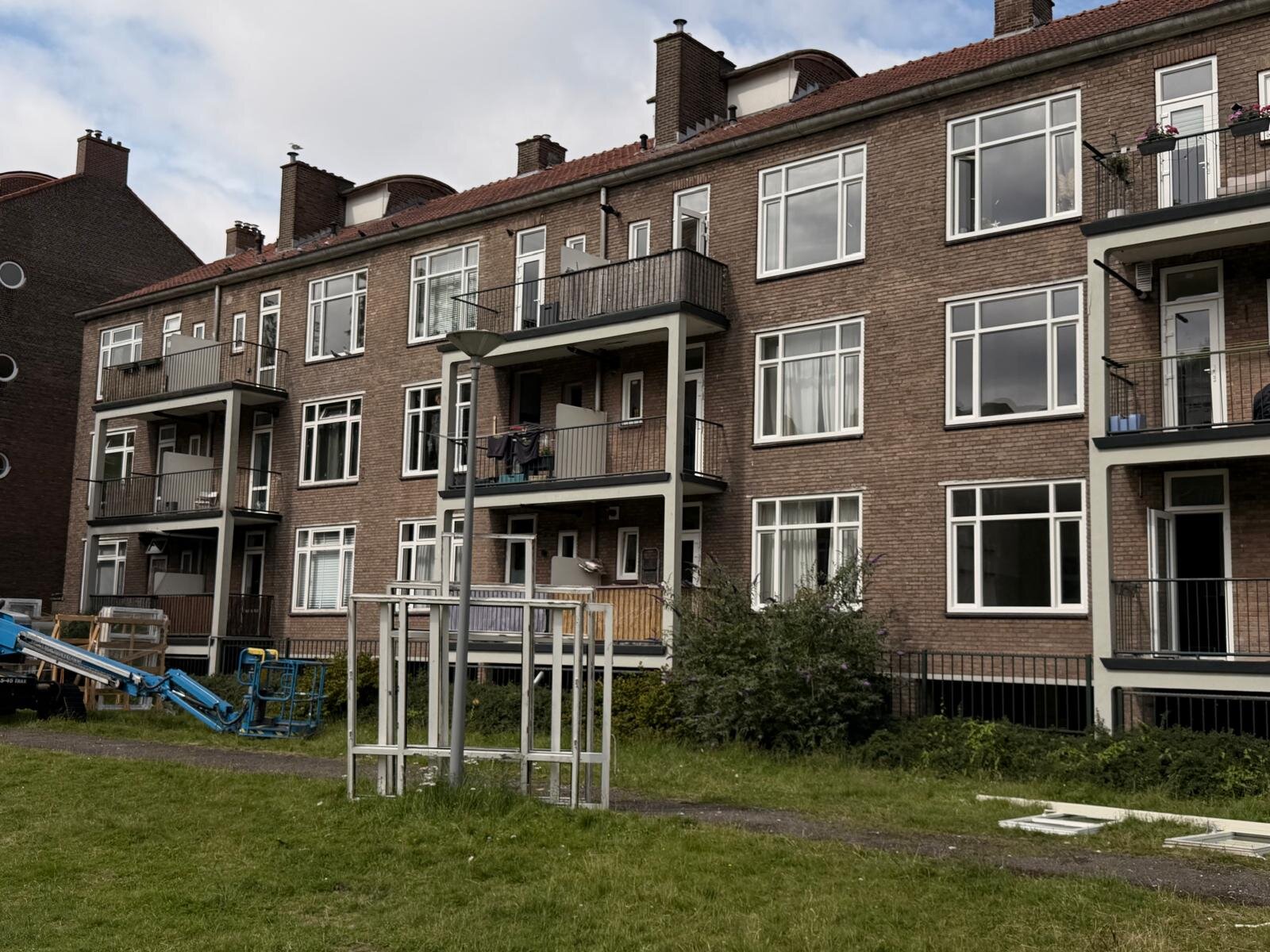 BGS Rotterdam: gevel met hoogwerker en afvoercontainer op de bouwplaats