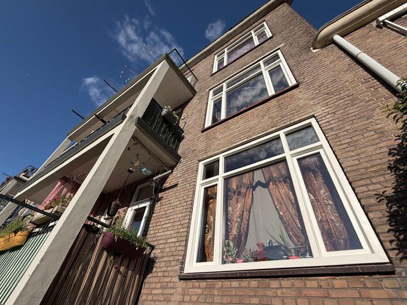Gevel met nieuw kozijn naast het balkon, van onderaf gezien