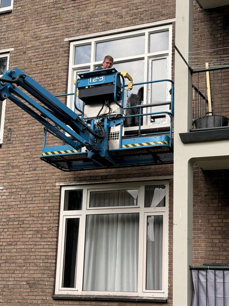 Monteur in de hoogwerker bij een bovenwoning